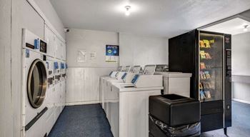 A laundromat with a washer and dryer on the left and a vending machine on the right.